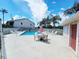 Community pool with lounge chairs and table at 2067 Hunters Glen Dr # 313, Dunedin, FL 34698