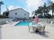 Community pool with lounge chairs and table at 2067 Hunters Glen Dr # 313, Dunedin, FL 34698