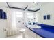 Bathroom with blue vanity, white tub, and whimsical fish tile at 3123 W Rio Vista Ave, Tampa, FL 33614