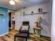 Bedroom with blue walls, wood floors, and a comfortable armchair at 4231 Tamargo Dr # 3, New Port Richey, FL 34652