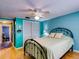 Bedroom with teal walls, wood floors, and a metal bed frame near closet at 4231 Tamargo Dr # 3, New Port Richey, FL 34652