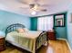 Bedroom with light teal walls, wood floors, and a metal bed frame at 4231 Tamargo Dr # 3, New Port Richey, FL 34652