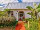 Charming bungalow with metal roof, lush landscaping, and a welcoming walkway at 4231 Tamargo Dr # 3, New Port Richey, FL 34652