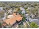 An aerial view of the home with an in-ground pool and distinctive metal roof in a lush neighborhood at 4829 W San Miguel St, Tampa, FL 33629