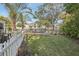 Green lush backyard with a canal view, green grass, and white picket fence at 4829 W San Miguel St, Tampa, FL 33629