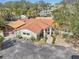 Aerial view of the charming home with lush landscaping, a metal roof, and serene canal access in a desirable neighborhood at 4829 W San Miguel St, Tampa, FL 33629