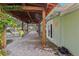 Covered patio with brick flooring, string lights and green lush tropical plans at 4829 W San Miguel St, Tampa, FL 33629