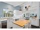 White kitchen with stainless steel appliances, butcher block island, and mosaic backsplash at 538 25Th Se Ave, St Petersburg, FL 33705