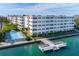 Aerial view of condo with a large pool, dock, and beautiful water views at 5575 Gulf Blvd # 425, St Pete Beach, FL 33706