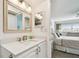 Well lit bathroom with white vanity and framed mirror with bedroom in background at 5575 Gulf Blvd # 425, St Pete Beach, FL 33706