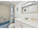Bathroom with white toilet and vanity with blue tub and shower at 5575 Gulf Blvd # 425, St Pete Beach, FL 33706