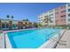 Community pool with lounge chairs and tropical plants surrounded by a fence at 5575 Gulf Blvd # 425, St Pete Beach, FL 33706