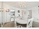 Bright dining room boasts white furniture, a stylish chandelier, and easy access to the kitchen at 5575 Gulf Blvd # 425, St Pete Beach, FL 33706
