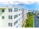 Exterior view of updated condo building with lush landscaping and ample parking at 5575 Gulf Blvd # 425, St Pete Beach, FL 33706