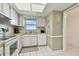 Well-lit kitchen features white appliances, tiled floors, and a window with natural light at 5575 Gulf Blvd # 425, St Pete Beach, FL 33706