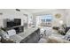 Bright living room featuring cozy seating and sliding glass doors to sunroom at 5575 Gulf Blvd # 425, St Pete Beach, FL 33706