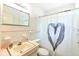 Clean bathroom with pink vanity and a heart shower curtain at 6105 Antrim St, New Port Richey, FL 34653