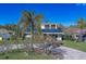 Bright yellow house with solar panels, palm trees, and a paved driveway at 783 Placido Ne Way, St Petersburg, FL 33704