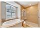 Bathroom with a large soaking tub, walk-in shower, and neutral tile at 1024 Sonata Ln, Apollo Beach, FL 33572