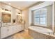 Spa-like bathroom with soaking tub, walk-in shower, and natural light at 1024 Sonata Ln, Apollo Beach, FL 33572