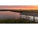 Covered boat dock with lift in calm waters at sunset at 1024 Sonata Ln, Apollo Beach, FL 33572