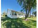 Home's backyard with lush grass and large oak tree at 11440 Baronwood Ct, Hudson, FL 34667