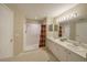 Bathroom with double sinks, shower, and linen closet at 11440 Baronwood Ct, Hudson, FL 34667
