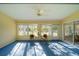Bright sunroom features windows, ceiling fan, and patio access at 11440 Baronwood Ct, Hudson, FL 34667