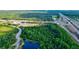 Aerial view of a road and lush green landscape near a pond at 12211 Oak Ramble Dr, Spring Hill, FL 34610