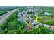 Aerial view of a house nestled in a residential neighborhood near a pond at 12211 Oak Ramble Dr, Spring Hill, FL 34610