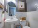 Clean bathroom with white pedestal sink, toilet, and shiplap wainscoting at 12211 Oak Ramble Dr, Spring Hill, FL 34610