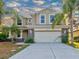 Two-story house with a beige facade and a two-car garage at 12211 Oak Ramble Dr, Spring Hill, FL 34610