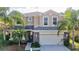 Two-story house with beige exterior, stone accents, and a two-car garage at 12211 Oak Ramble Dr, Spring Hill, FL 34610
