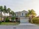 Two-story house with beige exterior, stone accents, and a two-car garage at 12211 Oak Ramble Dr, Spring Hill, FL 34610