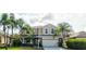 Two-story house with beige exterior, stone accents, and a two-car garage at 12211 Oak Ramble Dr, Spring Hill, FL 34610