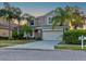 Two-story house with beige exterior, stone accents, and a two-car garage at 12211 Oak Ramble Dr, Spring Hill, FL 34610
