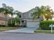 Two-story house with beige exterior, stone accents, and a two-car garage at 12211 Oak Ramble Dr, Spring Hill, FL 34610
