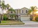 Two story house exterior with palm trees and a welcoming entrance at 12211 Oak Ramble Dr, Spring Hill, FL 34610