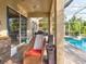 Relaxing patio with wicker chairs and access to a pool at 12211 Oak Ramble Dr, Spring Hill, FL 34610