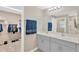 Double vanity bathroom with gray cabinets and a walk-in closet at 12931 Twin Bridges Dr, Riverview, FL 33579