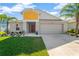 Two-story house with gray and yellow exterior, two-car garage, and landscaped lawn at 12931 Twin Bridges Dr, Riverview, FL 33579