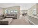 Spacious living room with L-shaped sofa, ottoman, and large windows at 12931 Twin Bridges Dr, Riverview, FL 33579