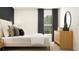 Modern bedroom with a white bed, light wood dresser, and gray curtains at 15233 Rainbow Quartz St, Wimauma, FL 33598