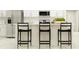 Modern kitchen island with seating for three and white quartz countertop at 15233 Rainbow Quartz St, Wimauma, FL 33598