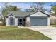 One-story house with gray garage door and well-maintained lawn at 1628 Baker Rd, Lutz, FL 33559