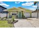 Charming light green house with a teal door, landscaped yard, and attached garage at 1742 Mississippi Ne Ave, St Petersburg, FL 33703