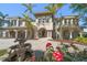 Stately two-story home featuring a grand entrance, fountain, lush landscaping and elegant architectural details at 26 Sunset Bay Drive, Belleair, FL 33756