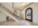 Foyer with staircase and an arched doorway entrance, complete with decorative details and tile flooring at 26 Sunset Bay Drive, Belleair, FL 33756