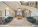 Expansive foyer featuring a winding staircase, elegant piano, seating, and travertine flooring at 26 Sunset Bay Drive, Belleair, FL 33756
