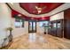Spacious game room boasting marble flooring, water view windows, and a striking red ceiling at 26 Sunset Bay Drive, Belleair, FL 33756